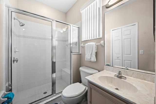 bathroom with vanity, toilet, and a shower with shower door