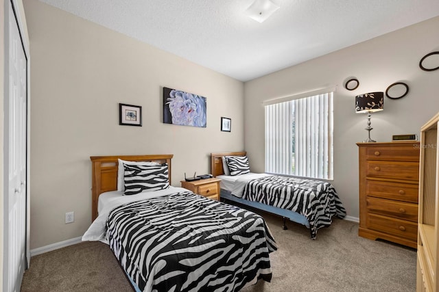 bedroom featuring light carpet, a closet, and a textured ceiling