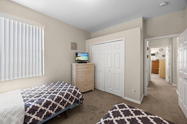 carpeted bedroom featuring a closet and a textured ceiling