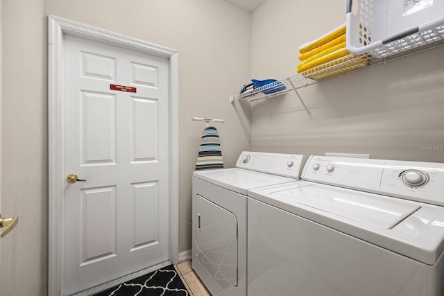 laundry room featuring independent washer and dryer and light tile patterned floors