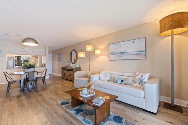 living room featuring light hardwood / wood-style flooring and a textured ceiling