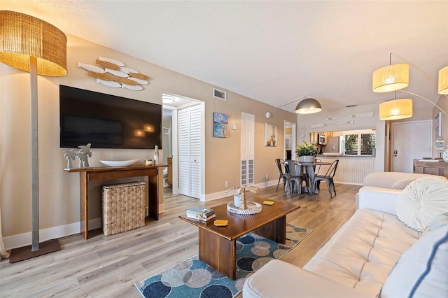 living room featuring a textured ceiling and light wood-type flooring