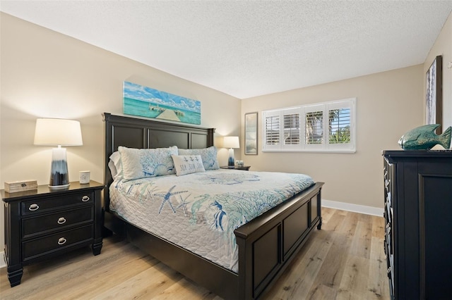 bedroom with light hardwood / wood-style floors and a textured ceiling