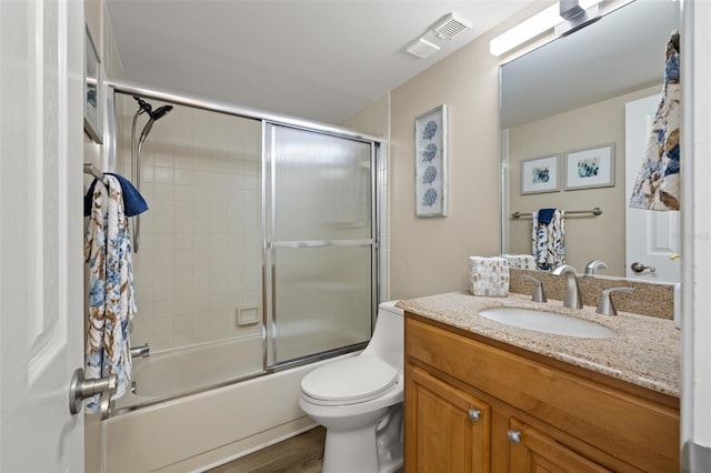 full bathroom with vanity, shower / bath combination with glass door, and toilet