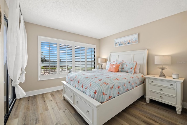 bedroom with a textured ceiling and light wood-type flooring