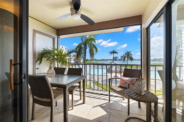 balcony featuring a water view and ceiling fan