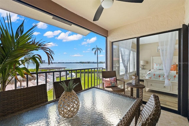 balcony featuring ceiling fan and a water view