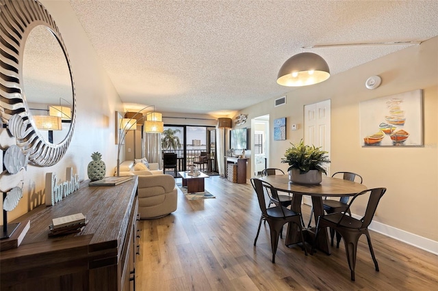 dining room featuring hardwood / wood-style floors and a textured ceiling