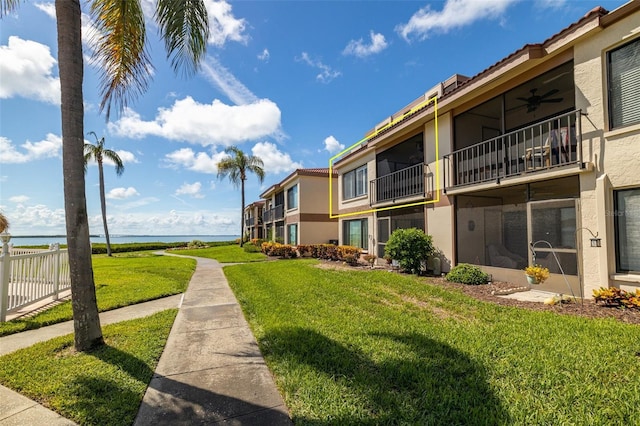 surrounding community with a water view and a yard