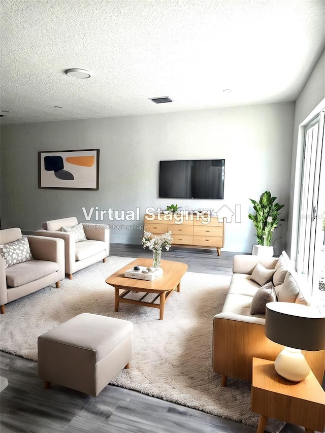 living room with hardwood / wood-style flooring and a textured ceiling