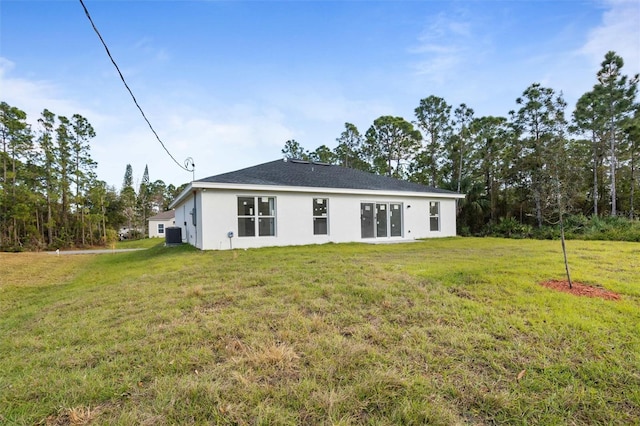 back of property featuring cooling unit and a lawn