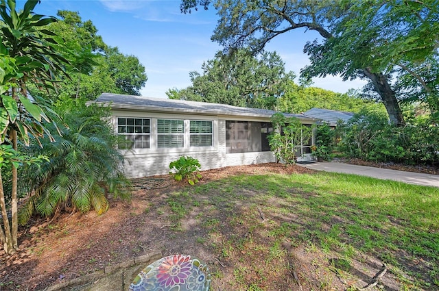 ranch-style home featuring a front lawn and a sunroom