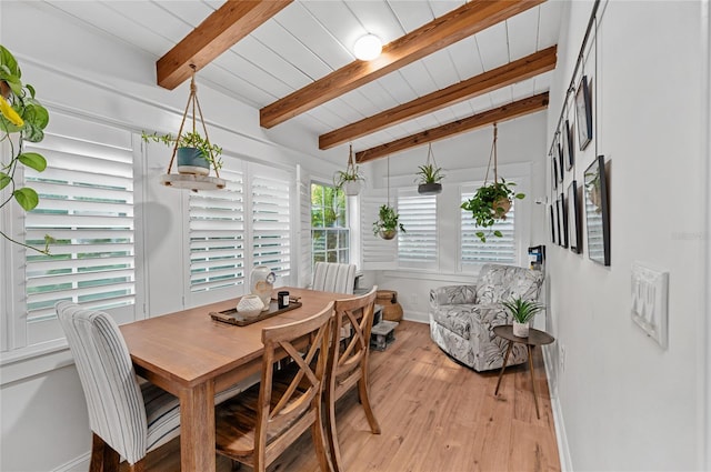 dining area featuring vaulted ceiling with beams, light hardwood / wood-style floors, and wooden ceiling