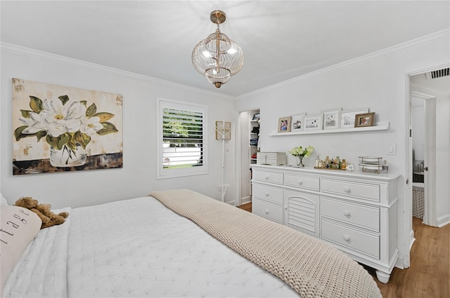 bedroom featuring a chandelier, ornamental molding, and dark wood-type flooring