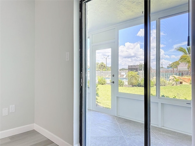 doorway to outside featuring baseboards