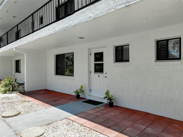 entrance to property with a patio area and stucco siding