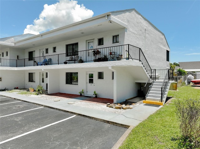 exterior space featuring stairs and uncovered parking