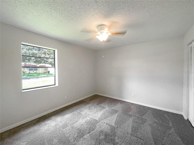 carpeted empty room featuring ceiling fan and a textured ceiling