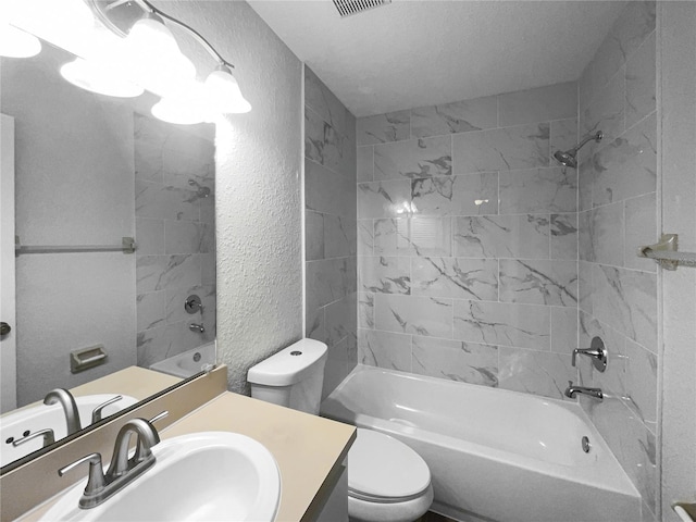 full bathroom featuring a textured ceiling, toilet, vanity, and tiled shower / bath combo