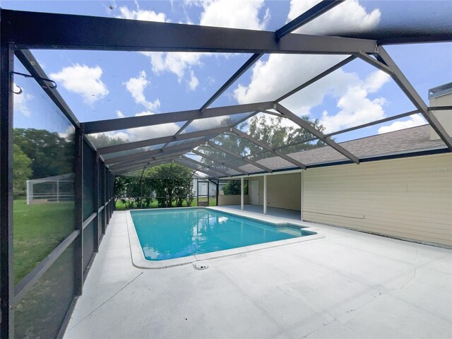 view of swimming pool featuring a lanai and a patio