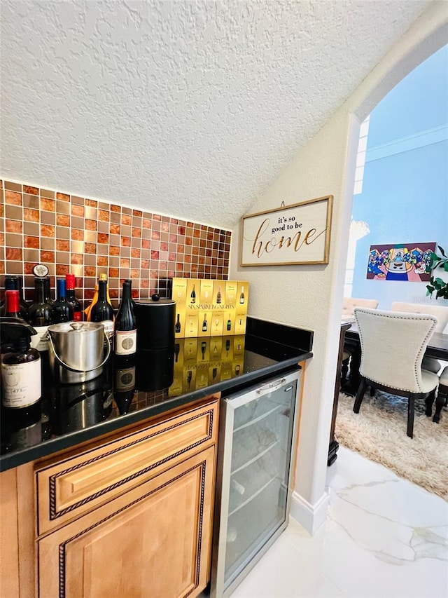 9060 Heritage Bay Cir, Orlando, FL 32836 - kitchen with a textured ceiling, backsplash, marble finish floor, dark countertops, and beverage cooler