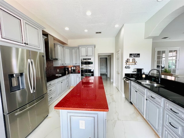 9060 Heritage Bay Cir, Orlando, FL 32836 - kitchen featuring a center island, marble finish floor, a sink, wall chimney range hood, and appliances with stainless steel finishes