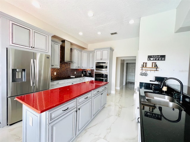 9060 Heritage Bay Cir, Orlando, FL 32836 - kitchen with marble finish floor, a sink, dark countertops, appliances with stainless steel finishes, and wall chimney exhaust hood