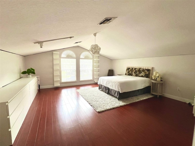 9060 Heritage Bay Cir, Orlando, FL 32836 - unfurnished bedroom with vaulted ceiling, a textured ceiling, baseboards, visible vents, and dark wood-type flooring