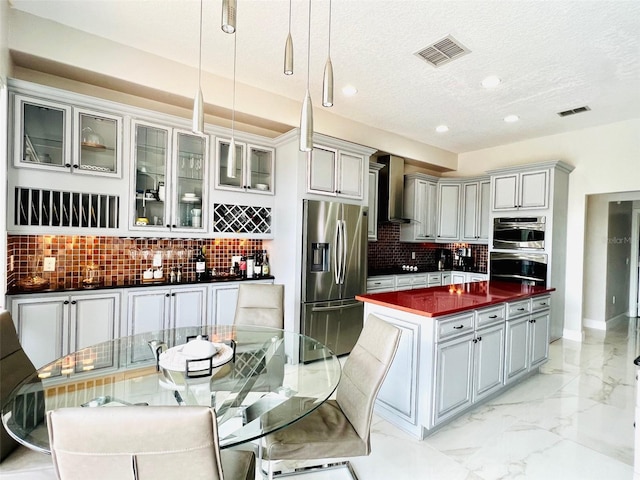 9060 Heritage Bay Cir, Orlando, FL 32836 - kitchen featuring visible vents, marble finish floor, stainless steel appliances, dark countertops, and wall chimney range hood