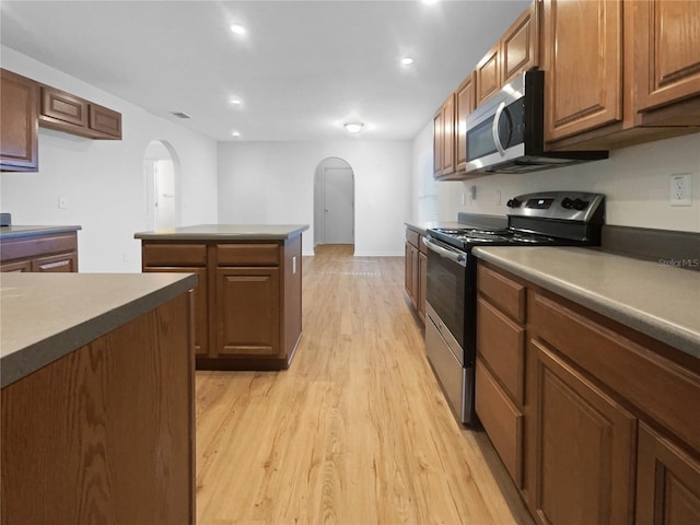 kitchen with appliances with stainless steel finishes and light hardwood / wood-style flooring