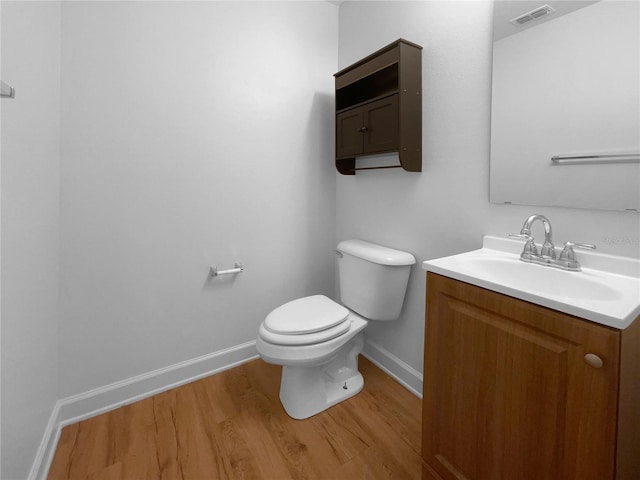 bathroom with vanity, hardwood / wood-style flooring, and toilet