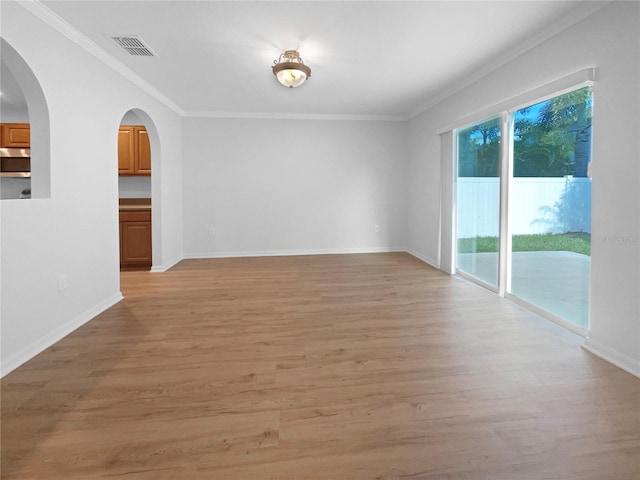 empty room featuring light hardwood / wood-style floors and crown molding