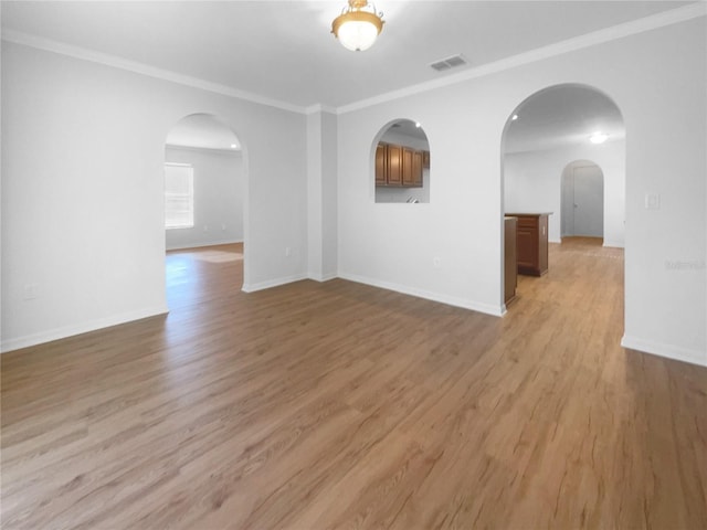 spare room with light wood-type flooring and crown molding