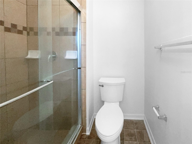 bathroom featuring toilet and a shower with shower door