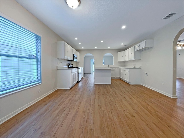 3444 97th Ln E, Palmetto, FL 34221 - unfurnished living room featuring arched walkways, light wood-type flooring, and recessed lighting
