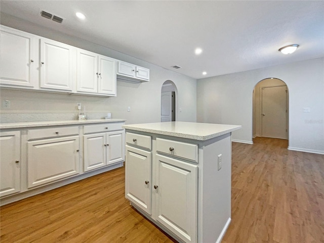 3444 97th Ln E, Palmetto, FL 34221 - kitchen with arched walkways, light wood-style floors, white cabinetry, and recessed lighting