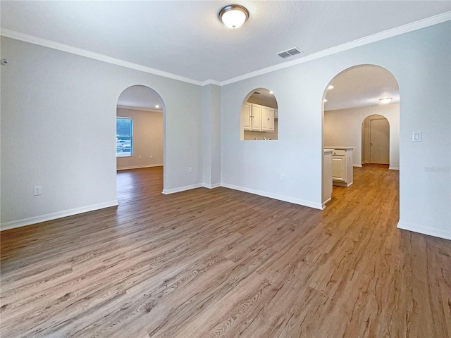 3444 97th Ln E, Palmetto, FL 34221 - empty room featuring light wood-style floors, crown molding, and arched walkways