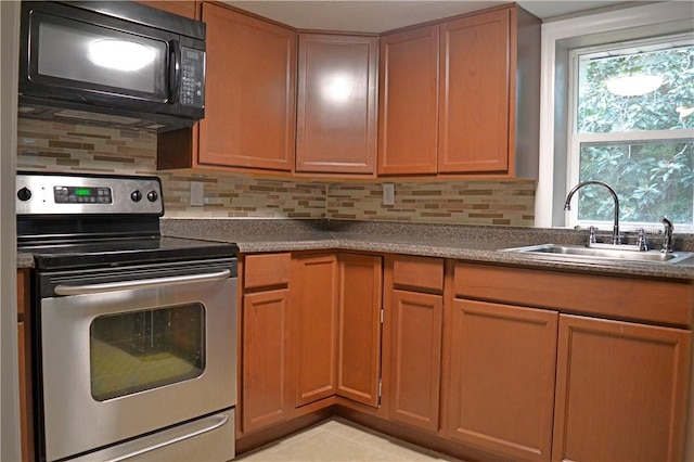 kitchen featuring tasteful backsplash, light tile patterned floors, sink, and electric range