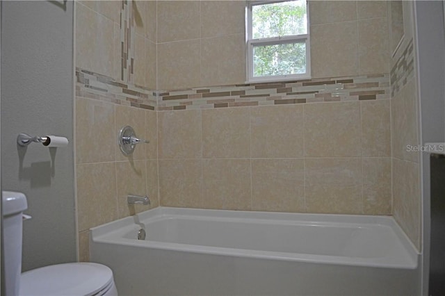 bathroom with toilet and tiled shower / bath combo