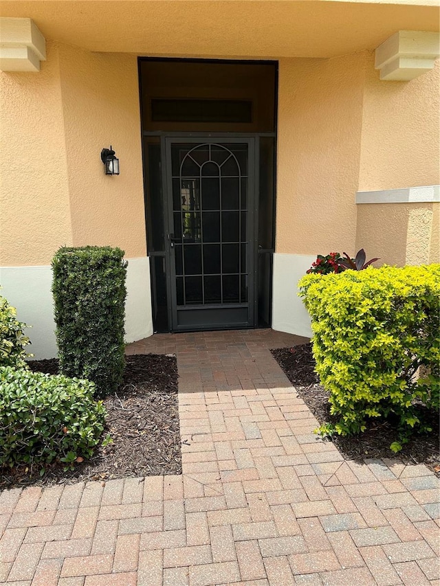 doorway to property featuring stucco siding