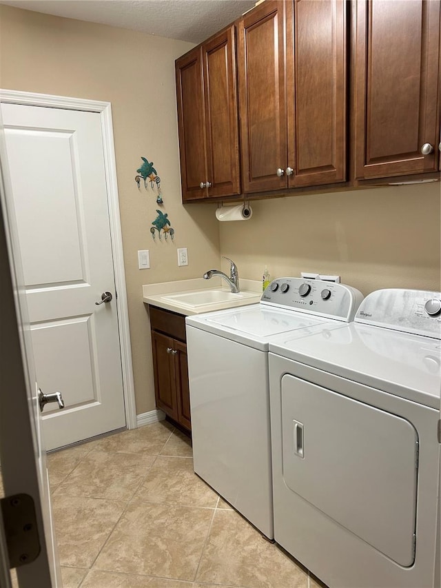 laundry room featuring a sink, cabinet space, light tile patterned floors, and washer and dryer