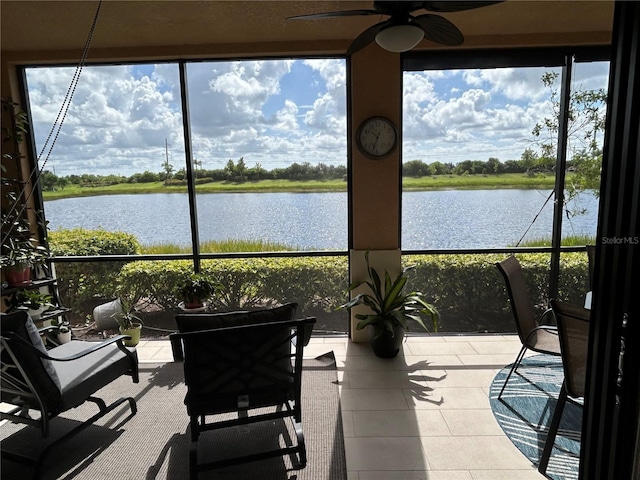 sunroom / solarium with a water view, a ceiling fan, and a healthy amount of sunlight