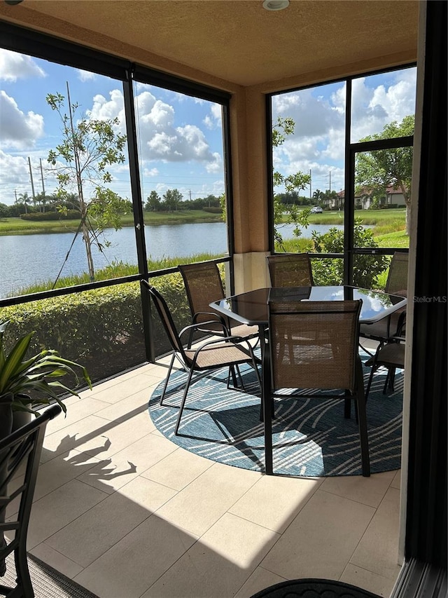 sunroom featuring a healthy amount of sunlight and a water view