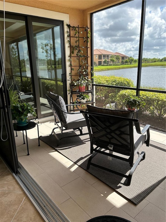 sunroom featuring a water view