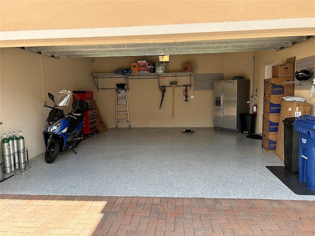 garage featuring stainless steel fridge with ice dispenser