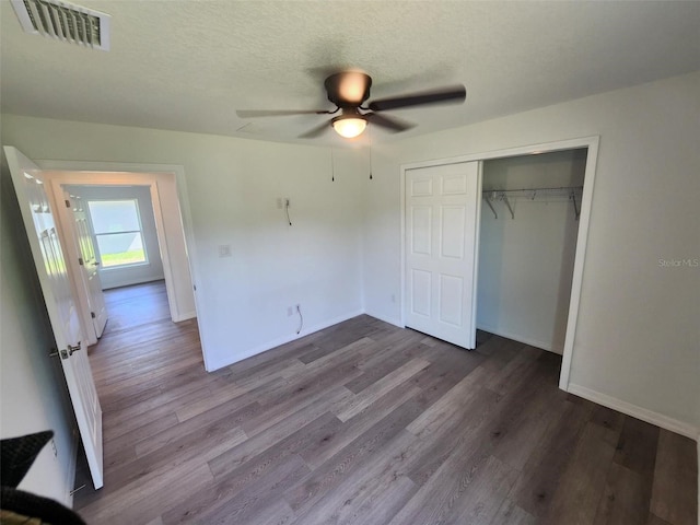 unfurnished bedroom featuring ceiling fan, hardwood / wood-style flooring, a closet, and a textured ceiling