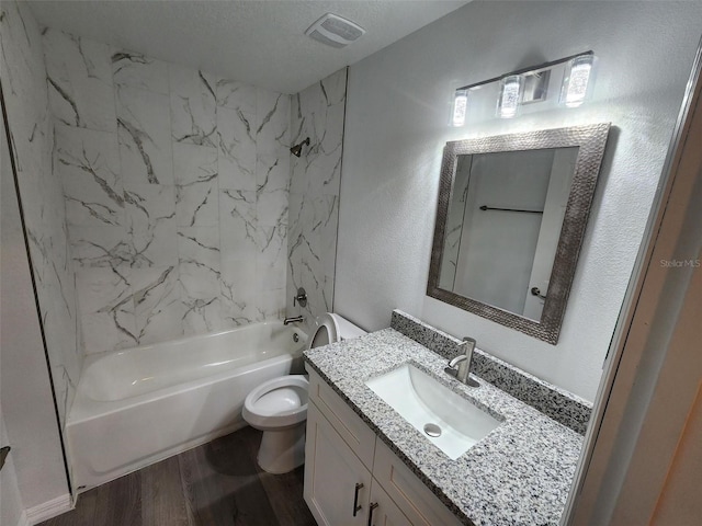 full bath featuring wood finished floors, visible vents, tub / shower combination, a textured ceiling, and toilet