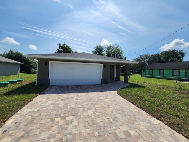 view of front of house featuring fence, stucco siding, a front lawn, a garage, and decorative driveway