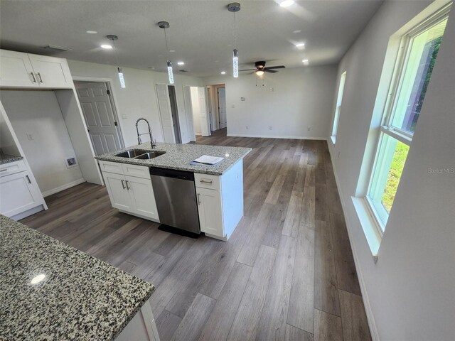 kitchen featuring ceiling fan, hardwood / wood-style floors, light stone counters, dishwasher, and sink