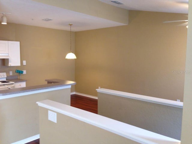 corridor featuring dark wood-style floors, visible vents, and baseboards